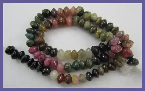A GRADE 5-6MM MULTI-COLORED TOURMALINE SMOOTH BUTTON BEADS